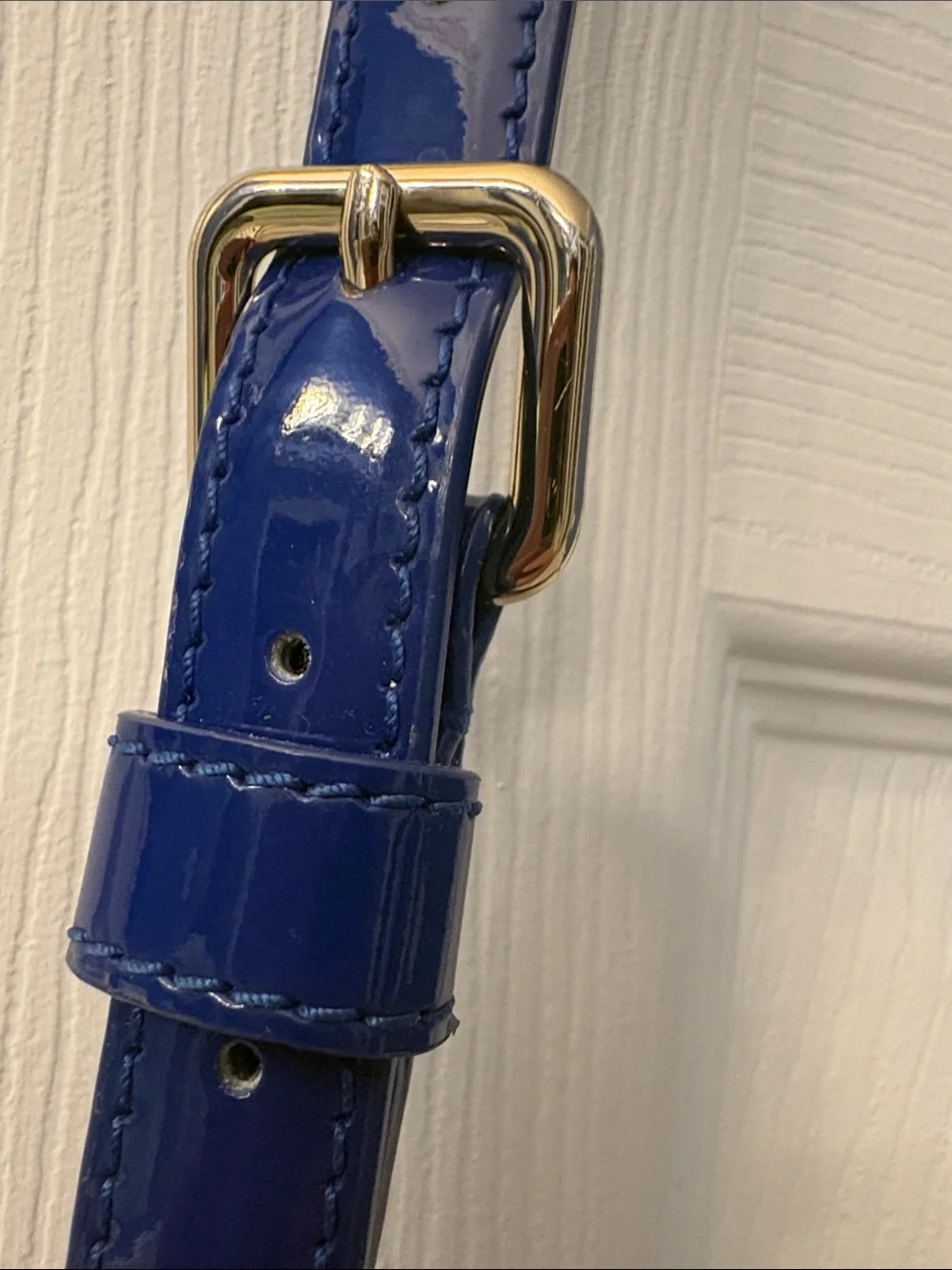 Kate Spade heart perforated patent leather crossbody in cobalt blue.